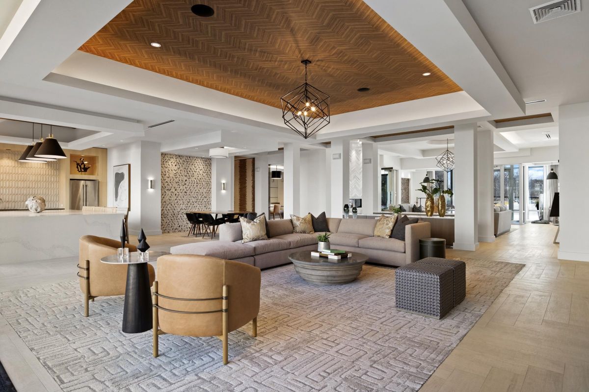 Spacious modern living room with a large sectional sofa, accent chairs, coffee table, and stylish lighting.