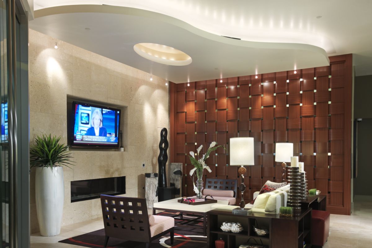 Modern lobby at Crescent at Fells Point with stylish seating, a TV, potted plant, and decorative wooden panel backdrop.