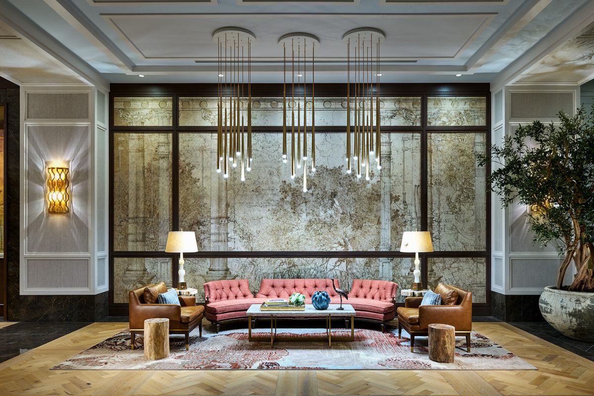 Luxurious Hanover lobby with a pink sofa, leather chairs, and stylish lights—perfect for Buffalo Bayou apartments.