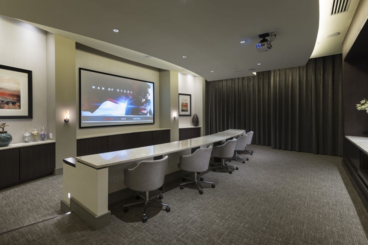 Modern conference room with long table, swivel chairs, and a large screen displaying "Man of Steel" in Shady Grove.