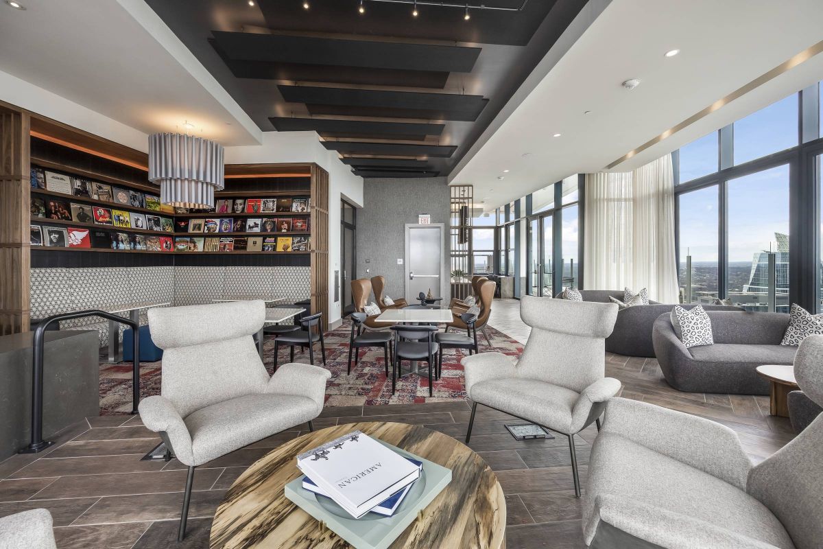 Hanover Company, Hanover Republic Square Modern lounge with gray chairs, wooden tables, bookshelves, and large windows offering city views.