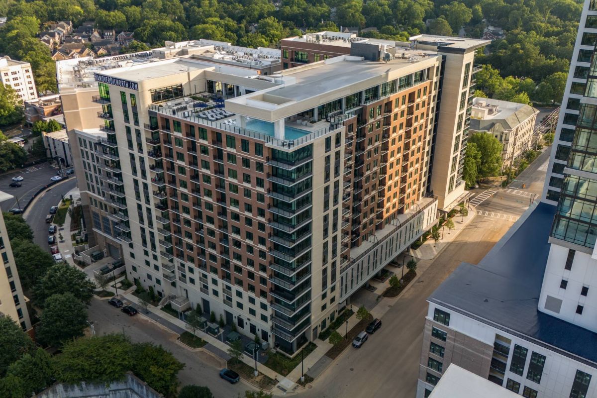 Hanover Company, Hanover Dilworth Aerial view of a large modern apartment building surrounded by trees and other buildings.