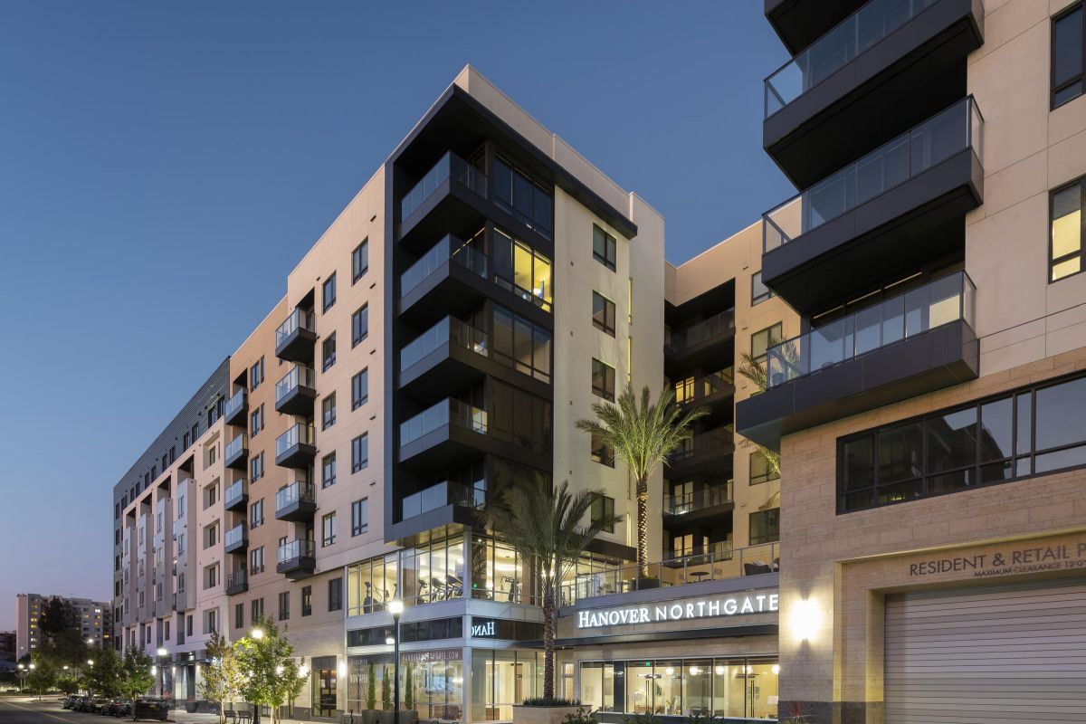 Street view of modern apartment buildings at dusk, featuring large windows and balconies labeled "Hanover Northgate.
