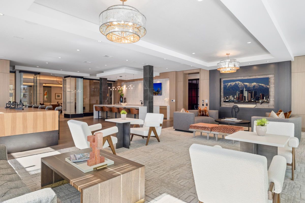 Modern lobby with elegant seating, warm lighting, and a cityscape painting on the wall.