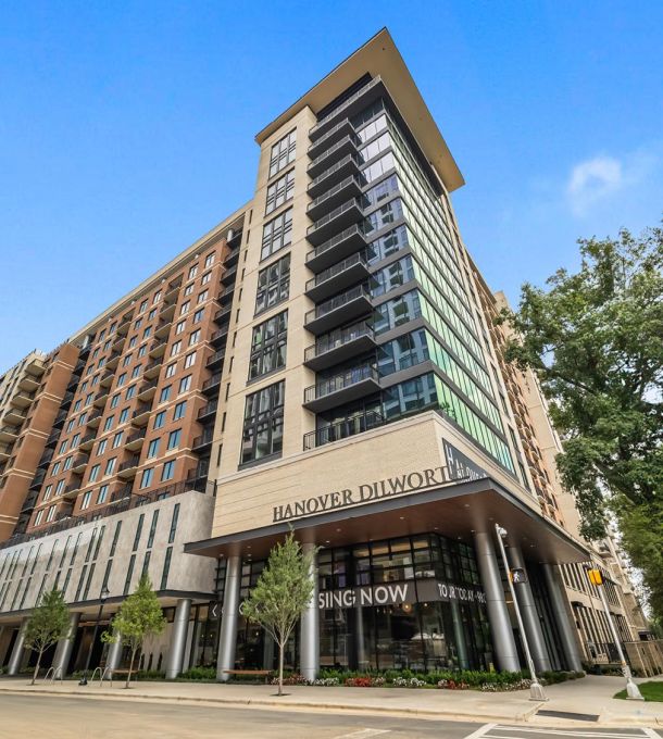 A modern high-rise apartment building with "Hanover Dilworth" and "Leasing Now" signs at the entrance.