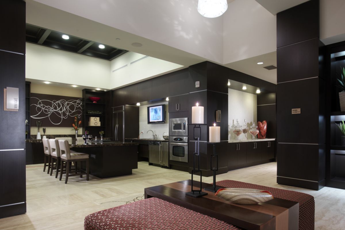 Modern kitchen with dark cabinets, island seating, stainless steel appliances, and contemporary decor.