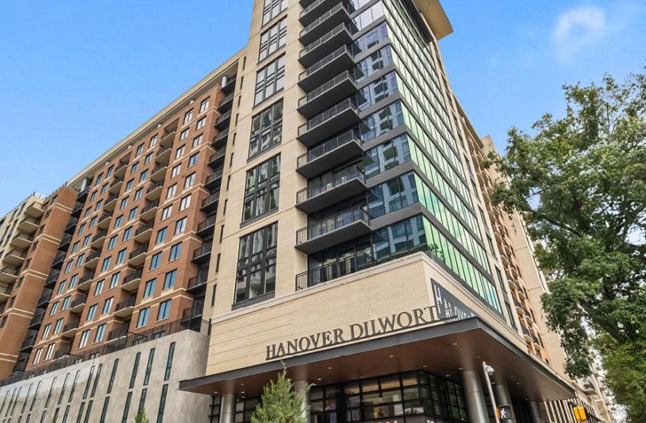 A modern high-rise apartment building with "Hanover Dilworth" and "Leasing Now" signs at the entrance.