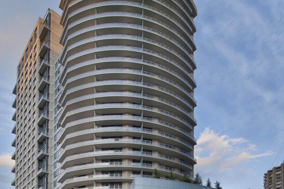 Modern high-rise building with curved balconies on a city street, under a partly cloudy sky.