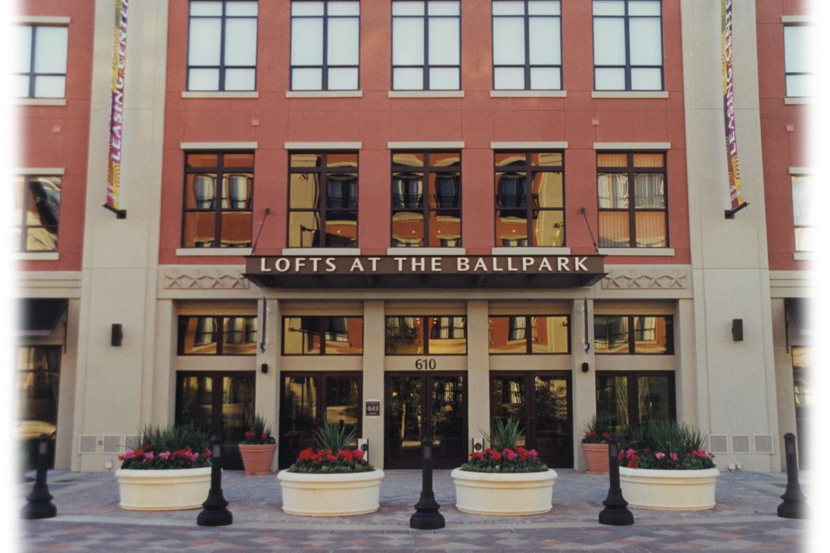 Entrance of "Lofts at the Ballpark" with large windows, planters, and address number 610 above the doors.