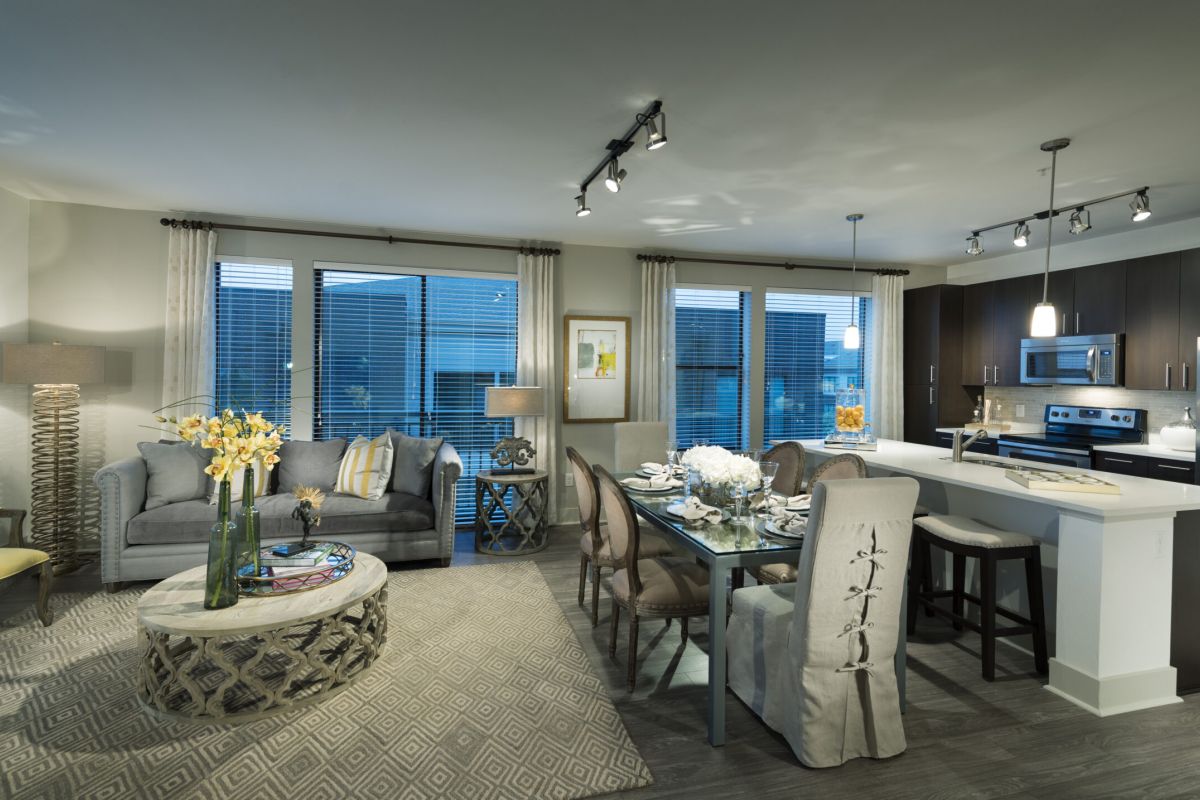 Modern open-concept living and dining area with elegant decor, large windows, and a stylish kitchen.