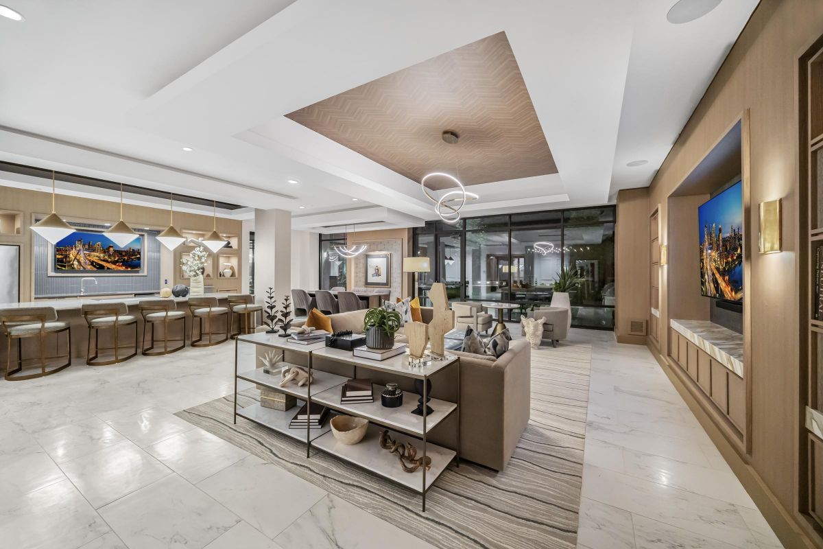 Modern, open-concept living room with a kitchen, stylish decor, and a large window showing a cityscape view.