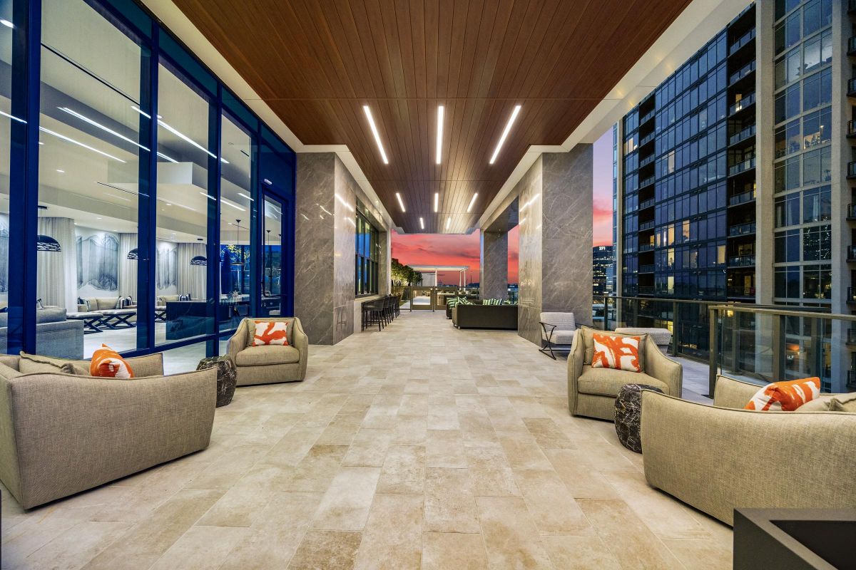 Modern terrace with cozy seating, city views, and a sunset sky in the background.
