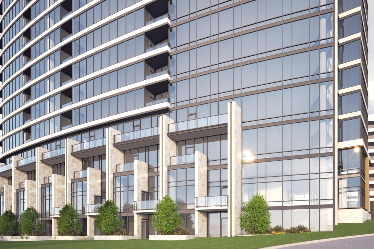 Modern high-rise building with large glass windows, stone accents, and small trees lining the ground level.