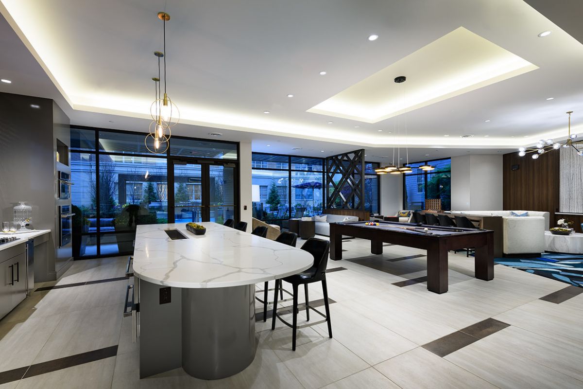 Modern open-concept lounge with kitchen, island seating, pool table, and spacious seating at Hanover Exton Square luxury apartments.