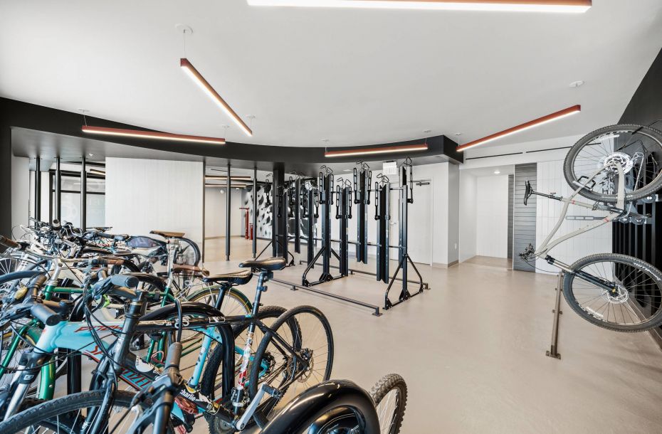 Hanover Company, Hanover Evans Station Room with multiple bicycles stored in racks, modern design, and overhead linear lights.