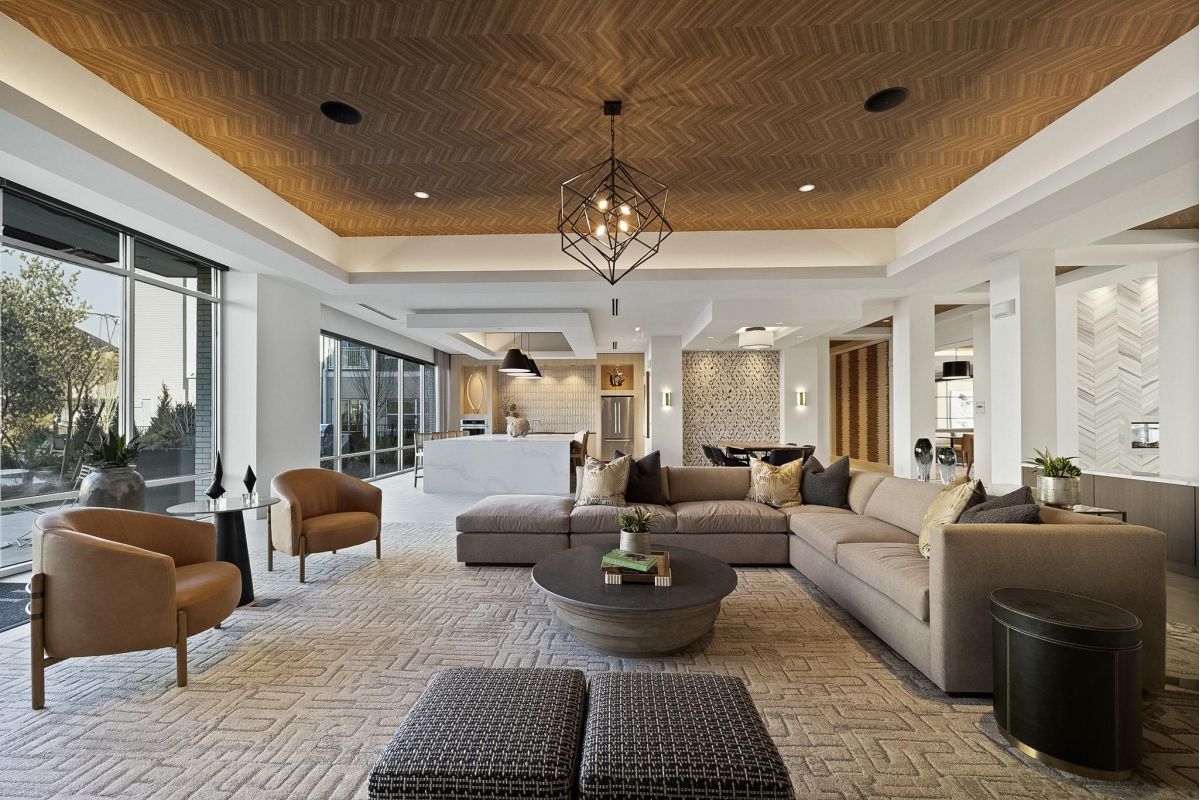 Modern living room with a large sectional sofa, stylish lighting, and floor-to-ceiling windows.