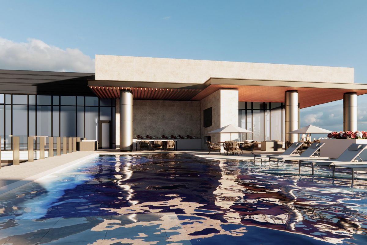 Rooftop pool area with lounge chairs, umbrellas, and a modern building in the background under a blue sky.