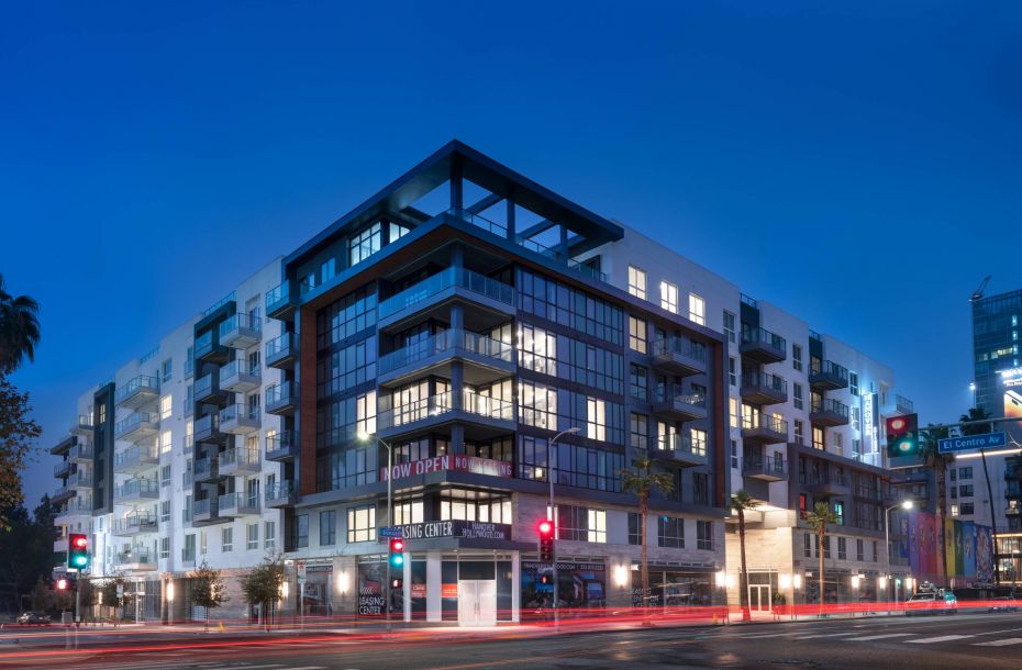 Hanover Company, Hanover Hollywood Modern apartment building at dusk with streetlights and a "Now Open" sign on the exterior.