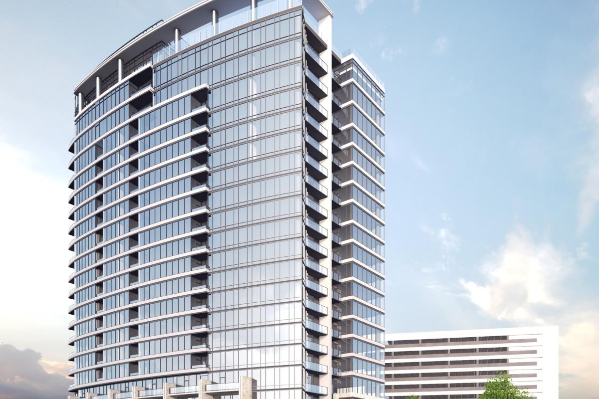 Modern high-rise building with glass facade, surrounded by greenery under a partly cloudy sky.