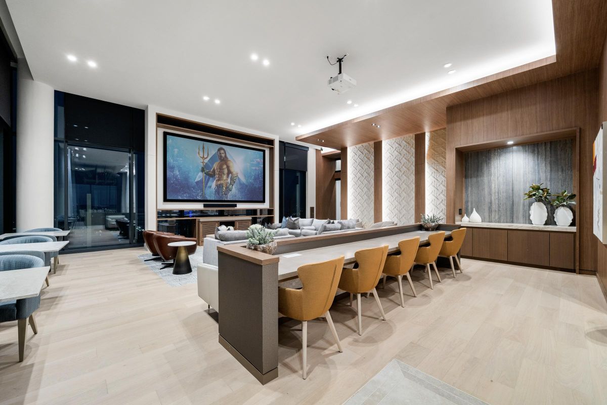 Modern home theater with a large screen, cozy seating, and contemporary decor.