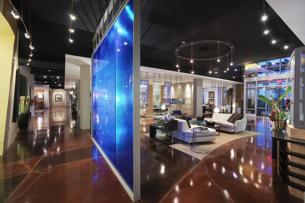 Modern lobby with a blue illuminated wall, polished floors, and contemporary seating area with sofas and chairs.