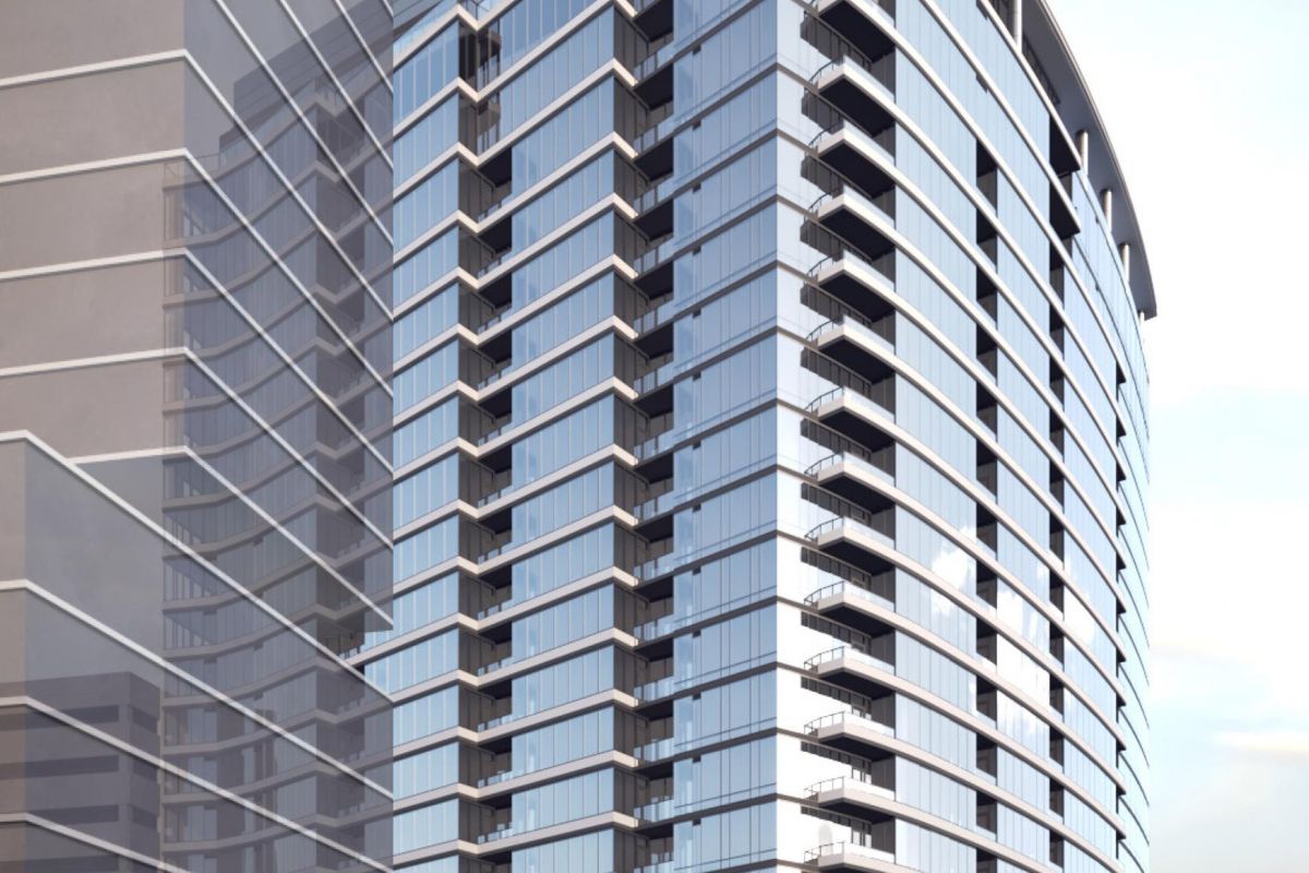 Modern glass skyscraper with balconies and a curved facade against a cloudy sky.