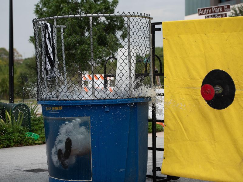 A dunk tank splashes as water is released, with a yellow target just hit nearby.