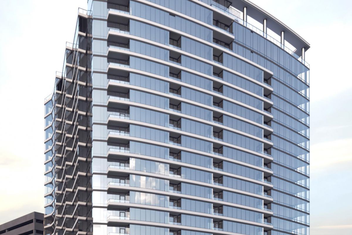 Modern glass high-rise building with balconies, against a clear sky.