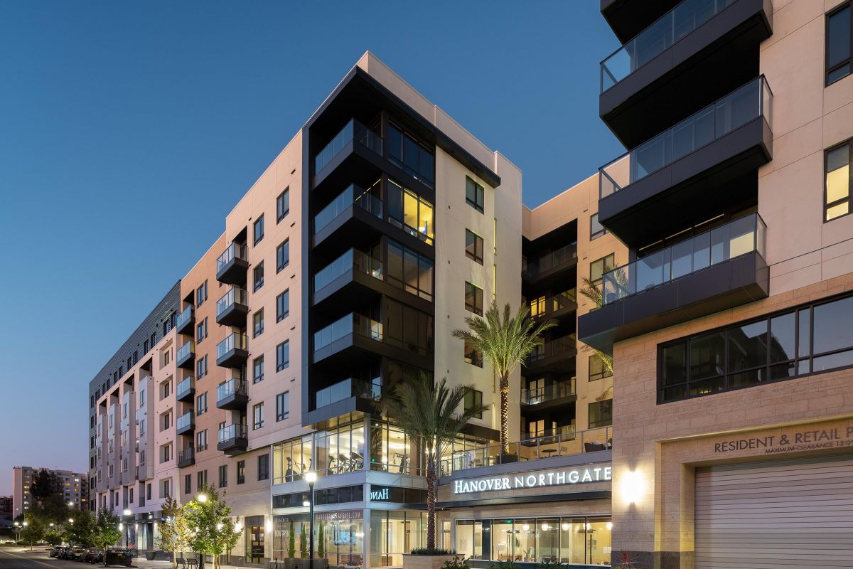 Modern apartment building at dusk with glass balconies and "Hanover Northgate" sign at the entrance.