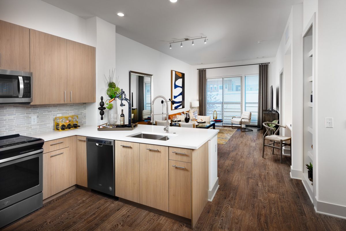 Modern Hanover kitchen with wood cabinets, stainless steel appliances, and an open view into a bright living room.