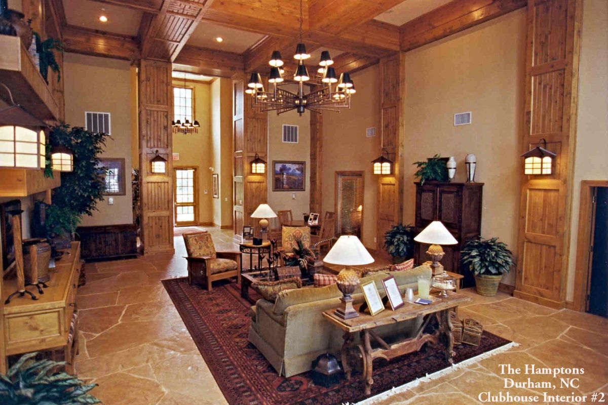 Spacious Broadwater Galveston clubhouse interior with wood accents, cozy seating, chandeliers, and large windows letting in natural light.