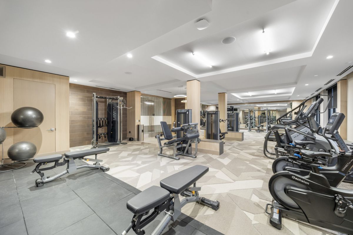 Modern Stoneham gym interior with weight benches, exercise bikes, fitness machines, and large mirrors on the walls.