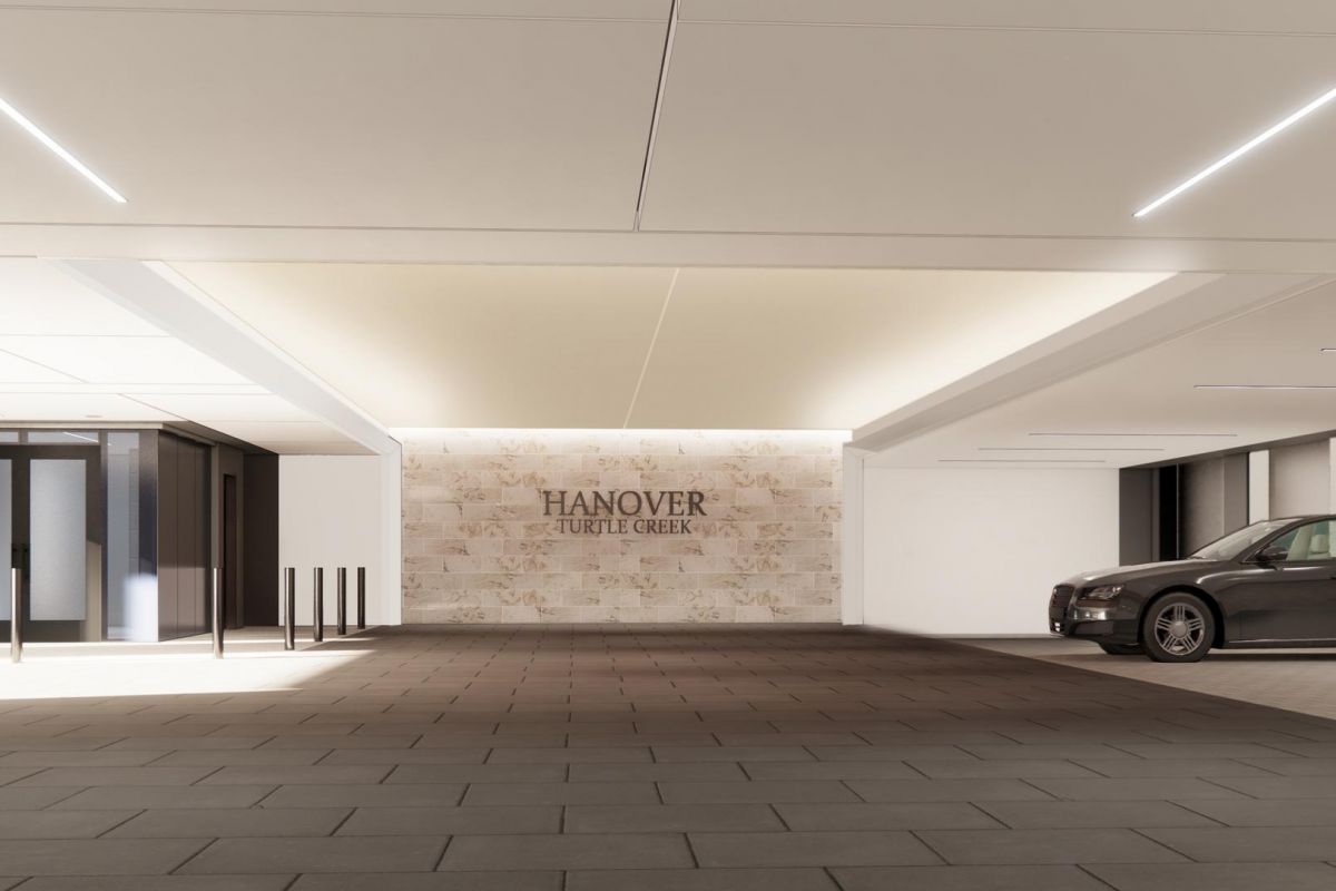 Modern car entrance with a luxury car parked near a sign reading "Hanover Village Green" on a wall.